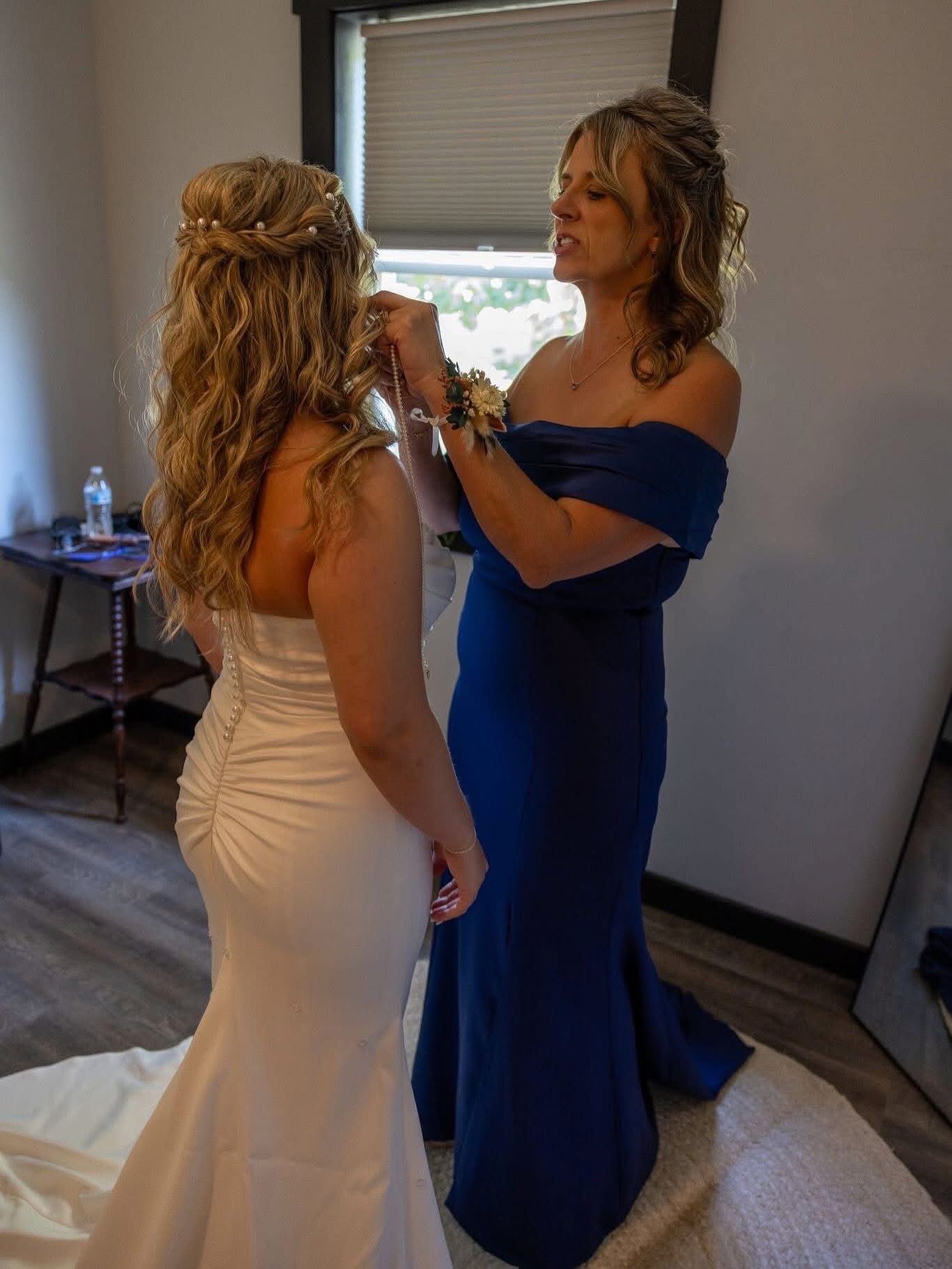 Two guests in formal gowns with styled hair