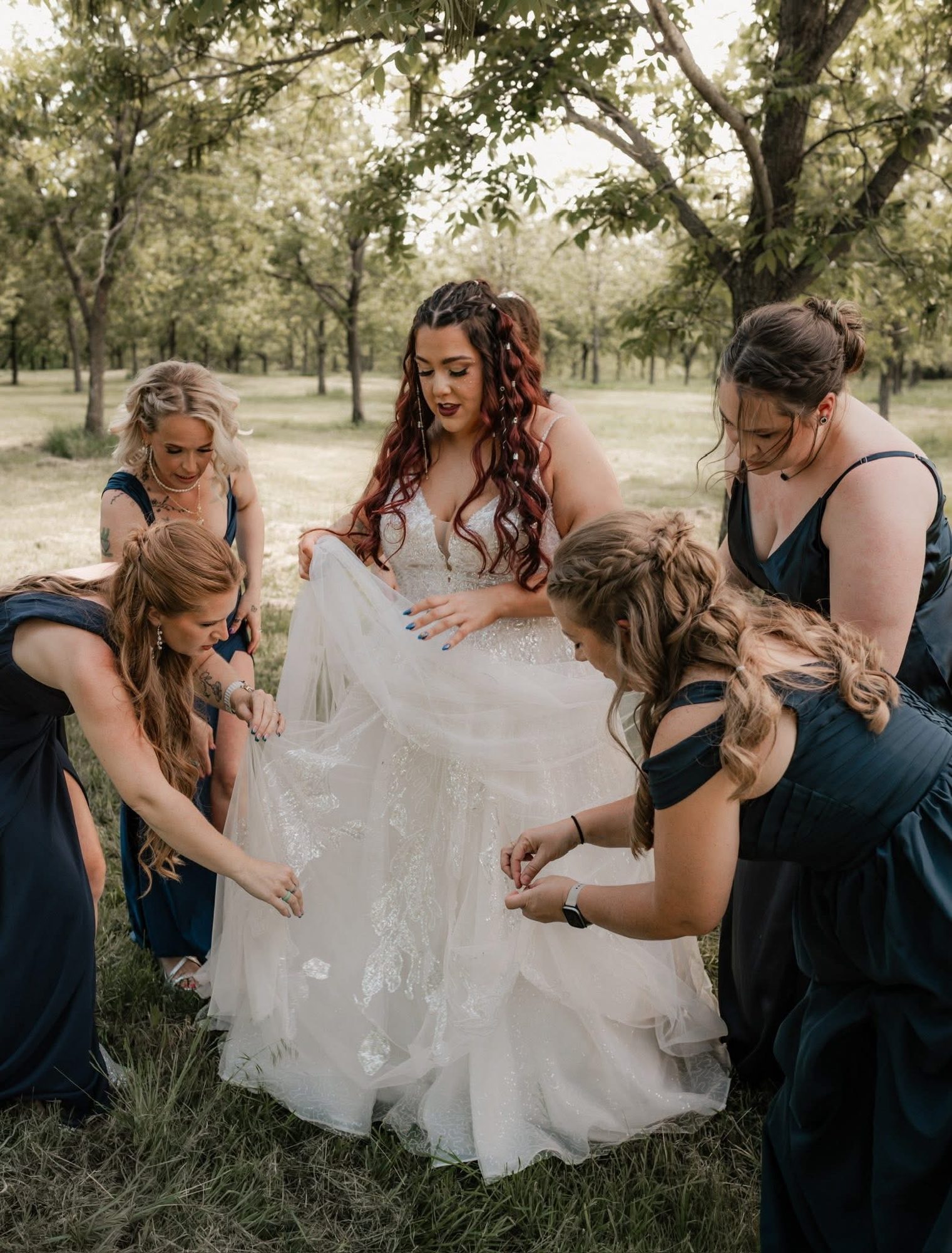 Bridesmaids helping the bride outdoors
